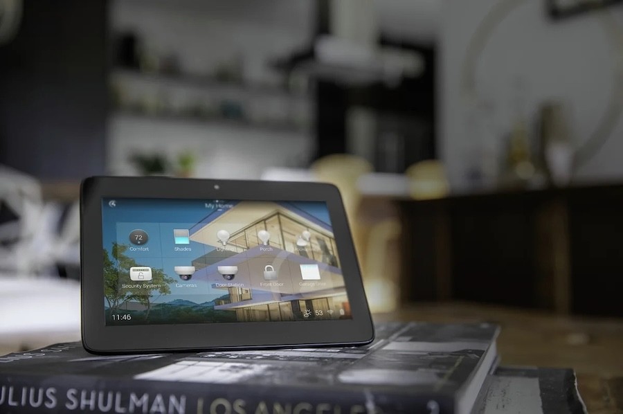  A Control4 touchscreen tablet sits on a stack of books.