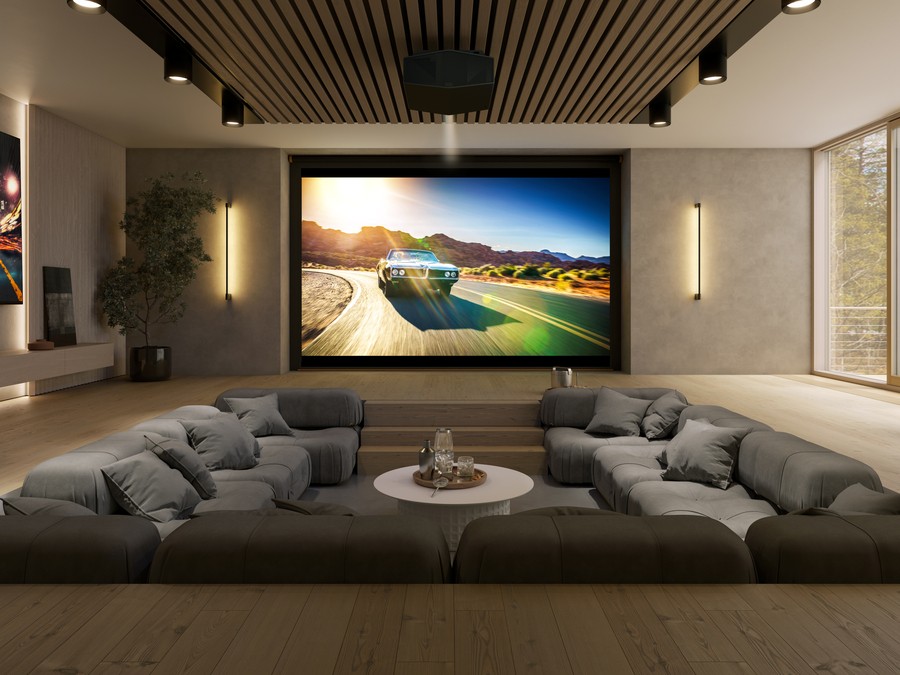 A media room with sunken seating, a large screen, and a Sony projector.