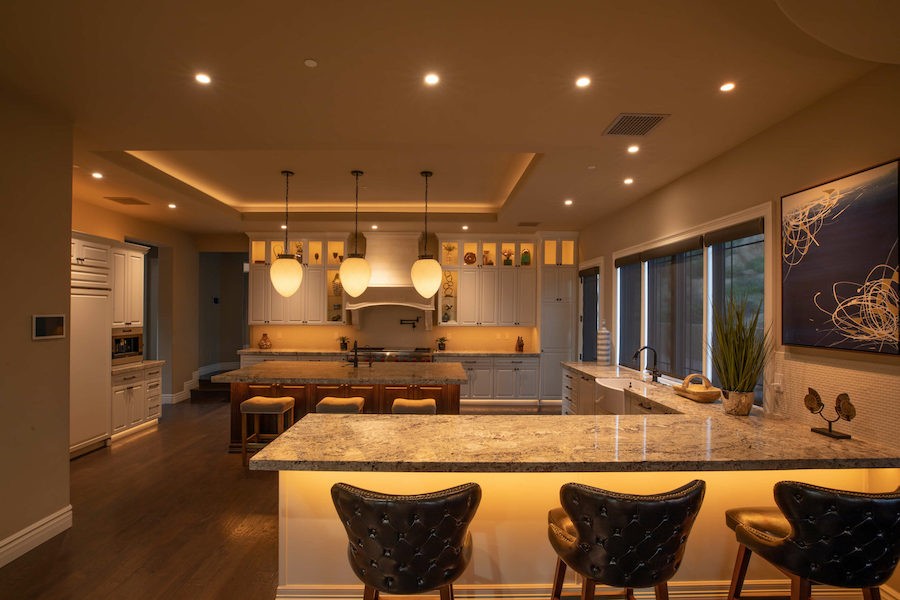 A modern kitchen illuminated by Vibrant Linear Lighting by Control4. 